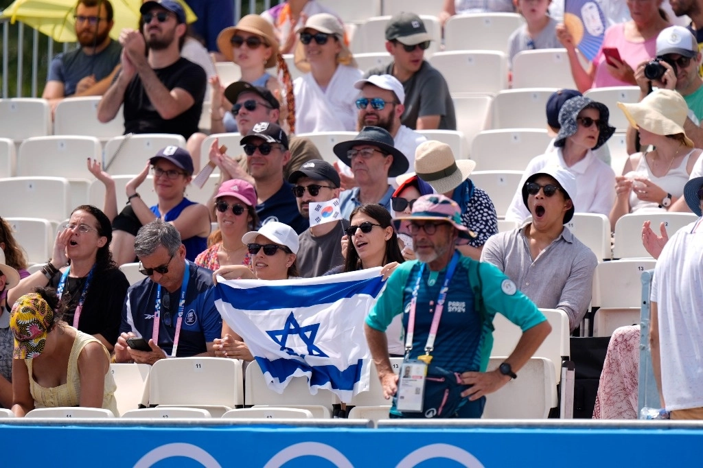 Mujer israelí apoya a los deportistas de su país durante las pruebas de tiro con arco. Foto Ap