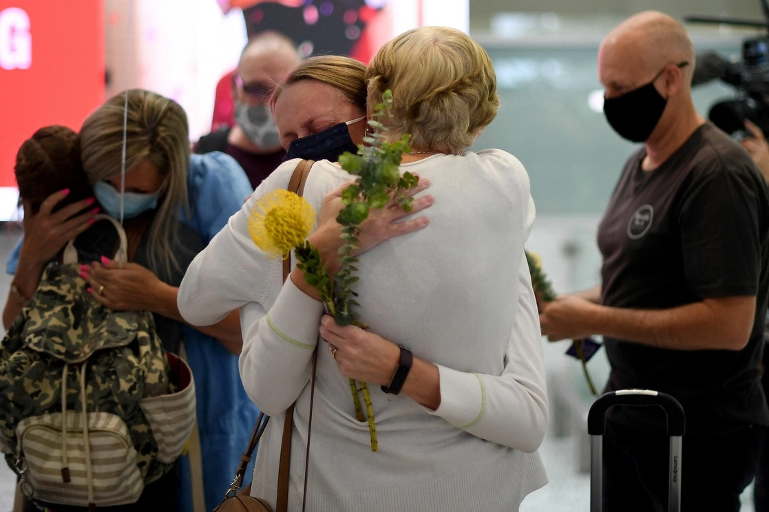 Familias se volvieron a abrazar después de reunirse en el aeropuerto de Sidney, por primera vez en casi 600 días, el 1 de noviembre de 2021. Foto Afp 