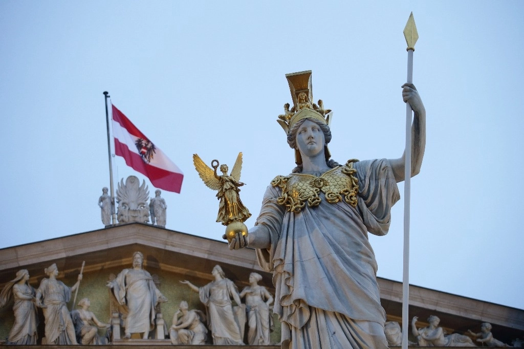 Una vista de la estatua de Palas Atenea, diosa griega de la sabiduría, frente a una bandera austriaca, en el Parlamento austriaco en Viena, Austria, el domingo 5 de enero de 2025, cuando el OEVP nominó el domingo al secretario general Christian Stocker como líder interino después de la esperada renuncia del canciller Karl Nehammer. Foto Ap