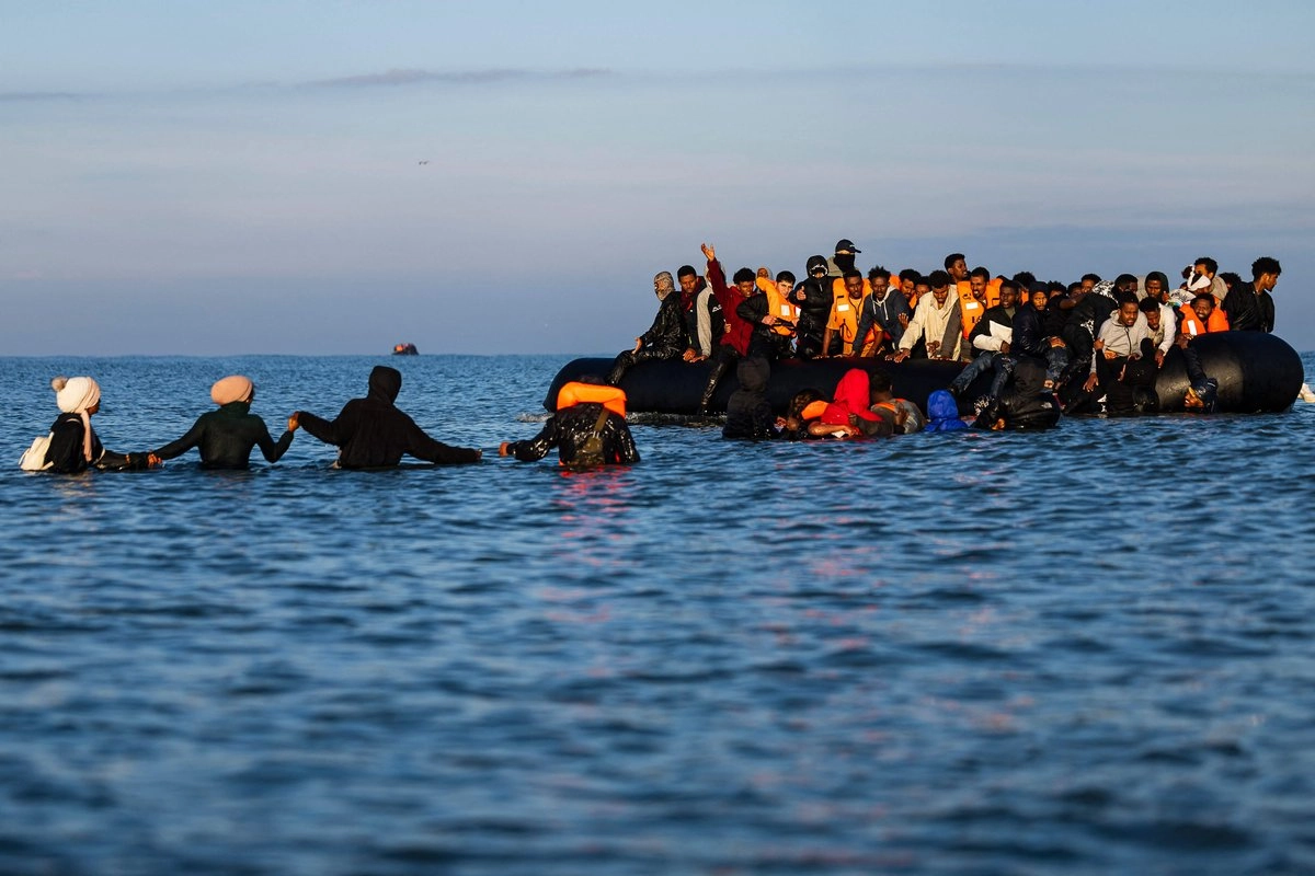 Migrantes se adentran en el mar para intentar abordar las embarcaciones de los traficantes e intentar cruzar el Canal de la Mancha frente a la playa de Gravelines, en el norte de Francia, el 27 de septiembre de 2025. Foto
