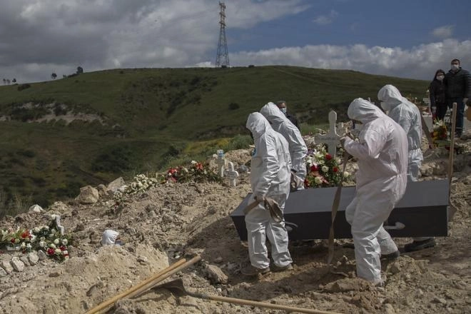 Los sepultureros portaban trajes herméticos. Foto La Jornada Baja California
