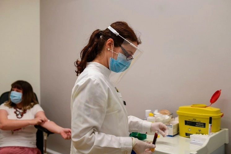 Una enfermera, en Lisboa, recolecta una muestra de sangre para prueba de Covid-19. Foto AFP
