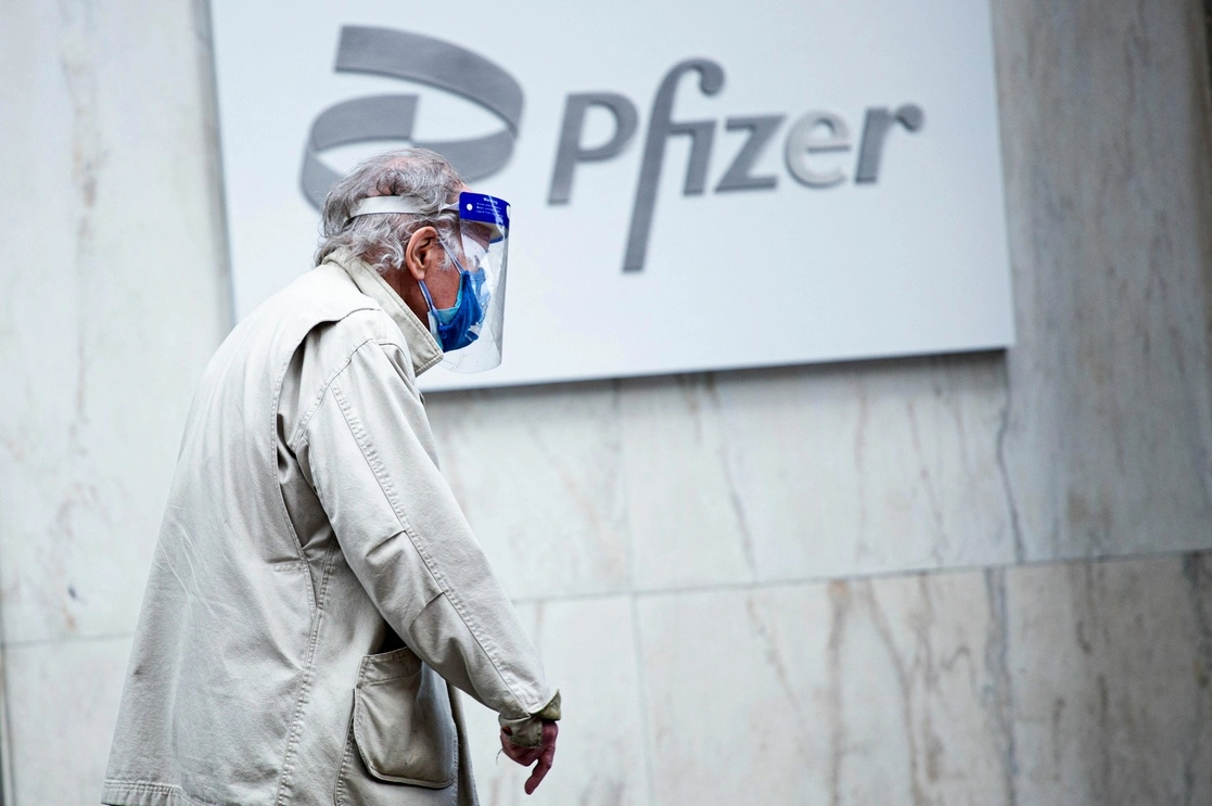 Un adulto mayor pasa enfrente a las puertas de uno de los laboratorio de Pfizer. Foto Afp
