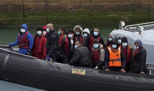 En imagen de archivo, la policía fronteriza traslada a Dover a un grupo de migrantes. Foto Ap

