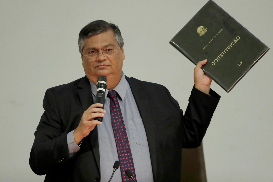 Con la Constitución de Brasil en alto, el ministro de Justicia, Flavio Dino, rindió ayer un homenaje a los agentes de seguridad que actuaron para detener a quienes invadieron y dañaron los edificios de las sedes del Ejecutivo, el Congreso y el Supremo Tribunal el pasado día 8. Foto Xinhua
