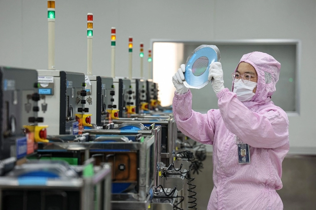 Una empleada revisa chips en una fábrica en Binzhou, en la provincia de Shandong. Foto Afp