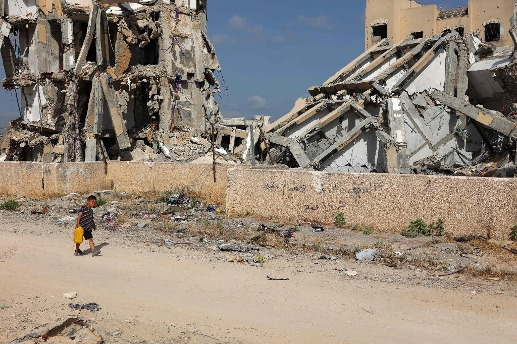 Un niño palestino lleva un bote de agua en Beit Lahya, en el norte de la Franja de Gaza, el 4 de mayo de 2024. Foto Afp