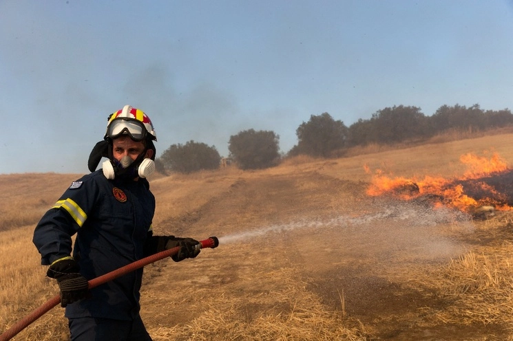 Un bombero intenta sofocar un incendio forestal, en las afueras de Volos, Grecia, el 27 de julio de 2023. Foto Xinhua