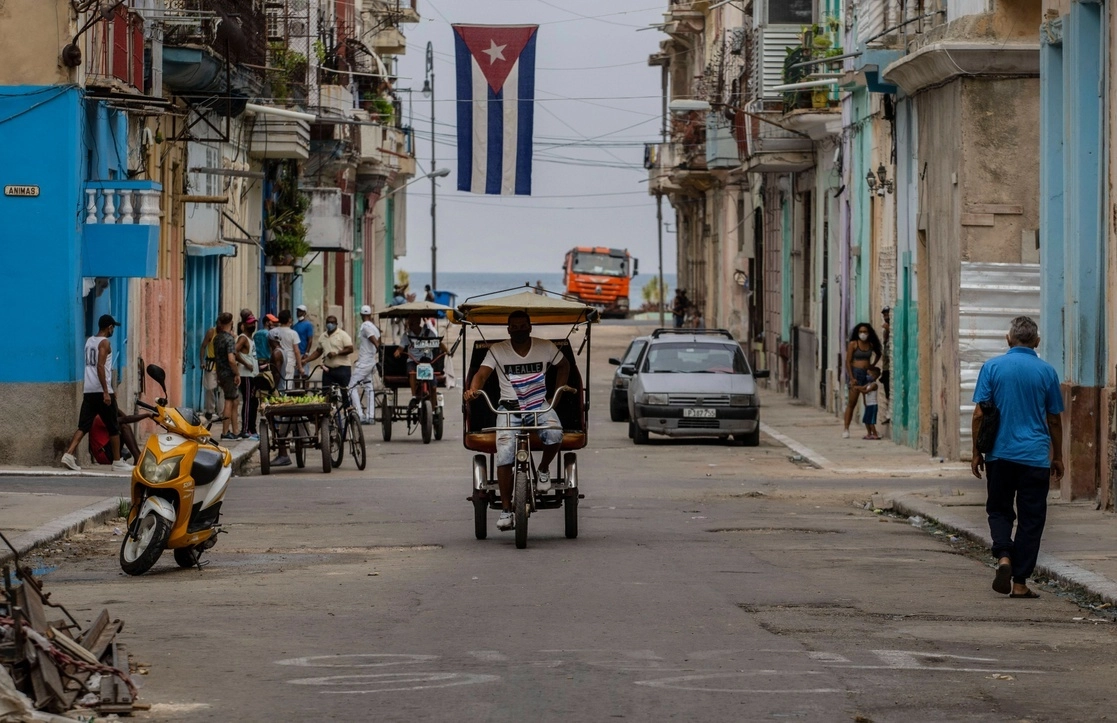 Bicitaxis, vendedores ambulantes y transeúntes en una calle de La Habana, el 26 de julio de 2021. Foto Ap
