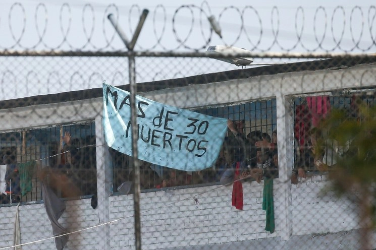 Reclusos muestran un cartel que dice "Más de 30 muertos" en la cárcel de La Modelo, en Bogotá, Colombia. La violencia estalló en la prisión por temor de que las autoridades no hagan lo suficiente para prevenir el coronavirus en el interior de la cárcel. Foto AP 