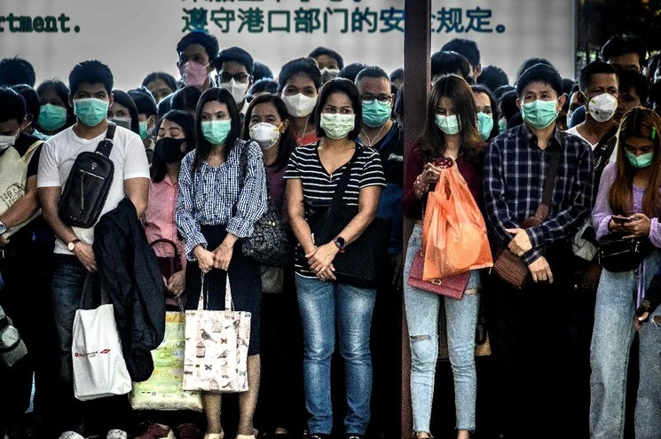En Bangkok personas con cubrebocas esperan en abordar un bote. Foto Afp 