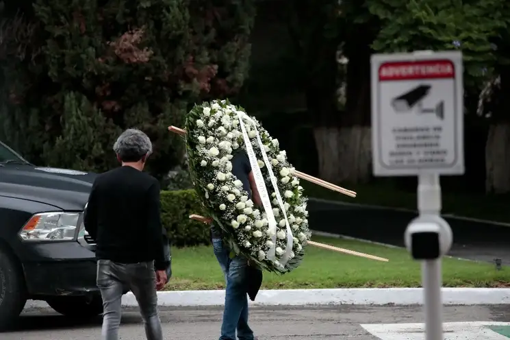 Una persona carga una corona de flores relativa a un funeral en calles de la Ciudad de México, el 9 de julio de 2023. Foto Luis Castillo