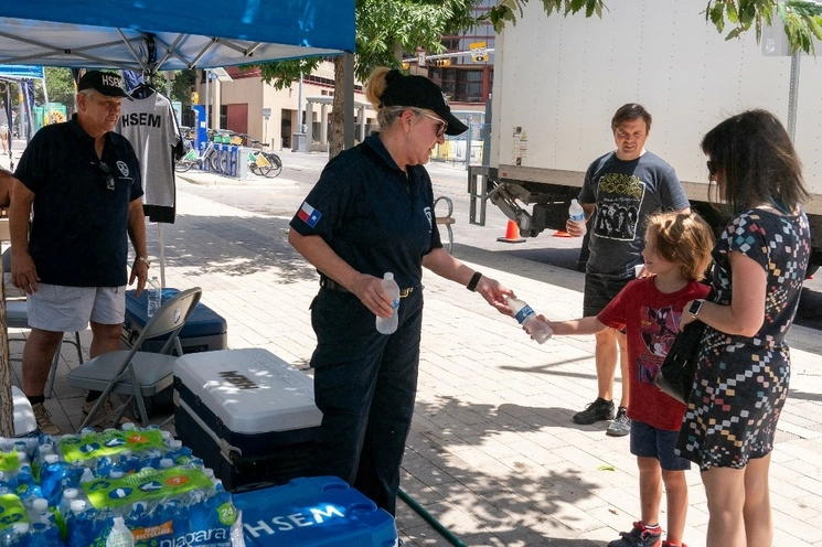 Un empleado de la Administración de Emergencias de Seguridad Nacional regala agua fría en Republic Park, en Austin, Texas. Decenas de millones de estadunidenses enfrentan temperaturas sofocantes por una implacable ola de calor. Foto Afp 