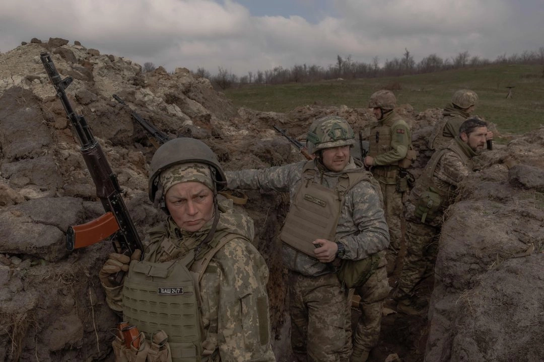 Natalia (izquierda), médica de combate y madre de tres hijos que sirve en la 24 brigada mecanizada del ejército ucranio, participa con otros militares en un ejercicio de entrenamiento de campo en la región oriental de ese país, en medio de la invasión rusa. Foto 
