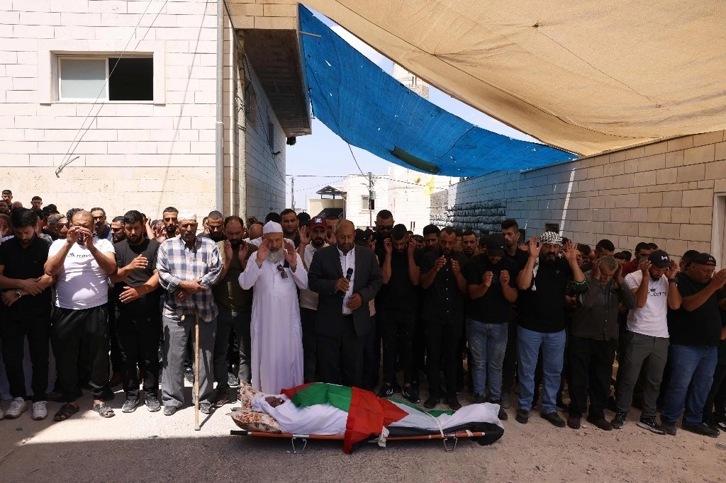 Rezos frente al cadáver del palestino Khalil Ziadeh, muerto el lunes durante un choque con colonos israelíes, en el pueblo cisjordano de Wadi Rahhal, al sur de Belén. Foto Afp