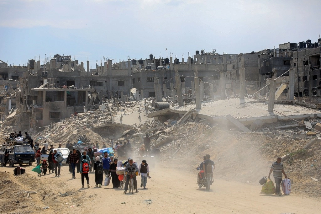 Palestinos retornan con sus posesiones a la destruida ciudad de Jan Yunis, en el sur de la franja de Gaza, el lunes, tras la salida de fuerzas israelíes de la zona. Foto Xinhua 




