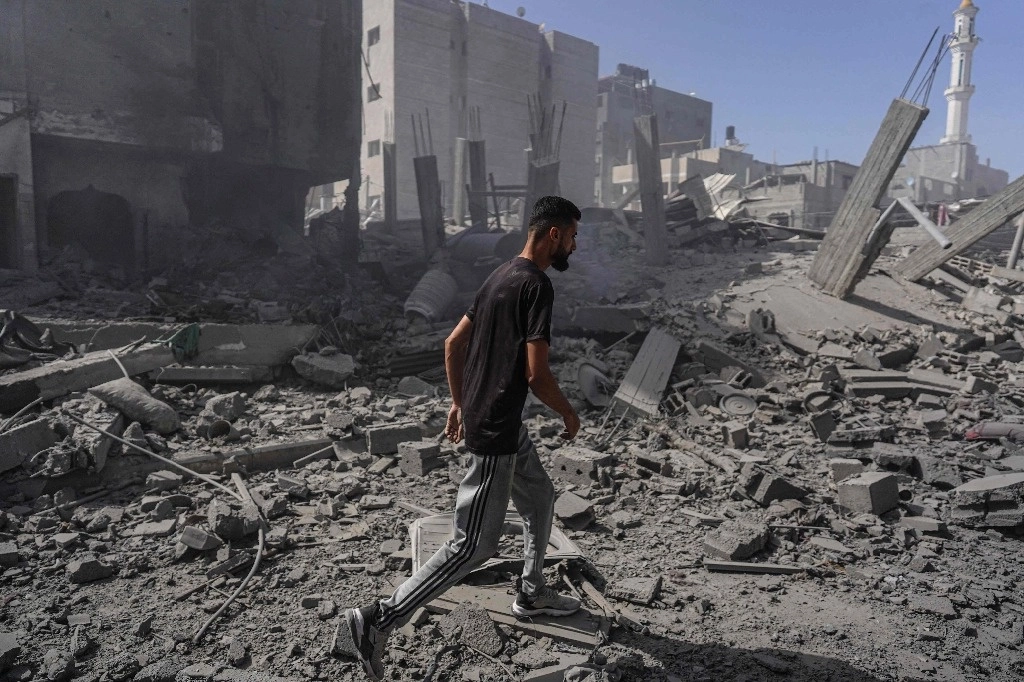 Un palestino inspecciona los escombros de unos edificios tras un ataque de las fuerzas especiales israelíes en el campamento de Nuseirat, en el centro de Gaza. Foto Afp 
