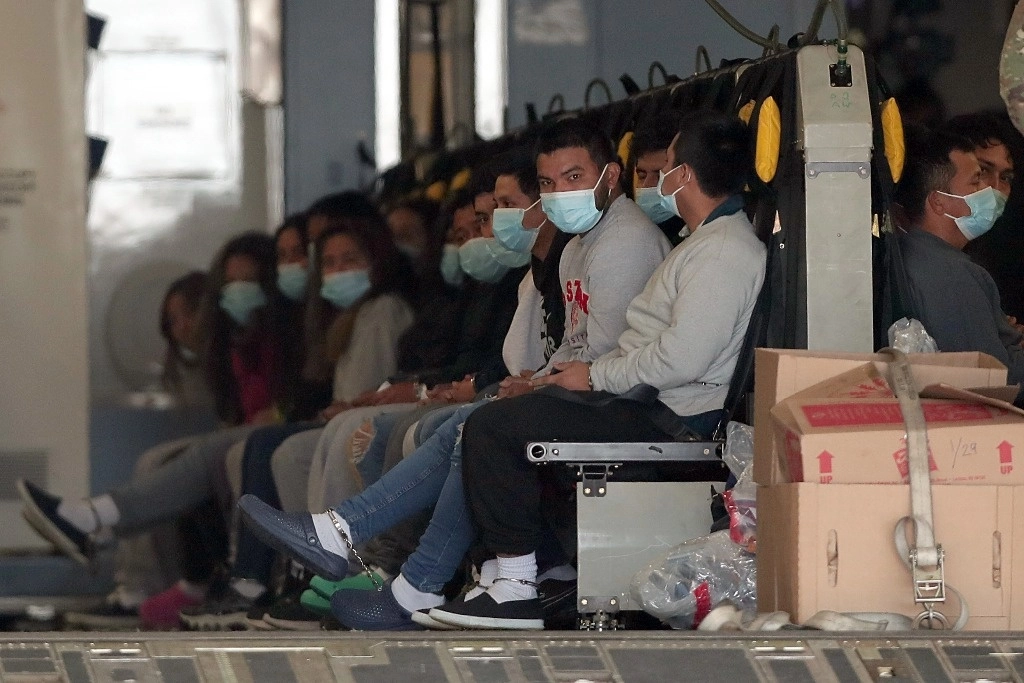 Migrantes con cubrebocas y esposados son acomodados en un avión militar en Fort Bliss en El Paso, Texas, el jueves 30 de enero de 2025, esperando su deportación a Guatemala. Foto AP  