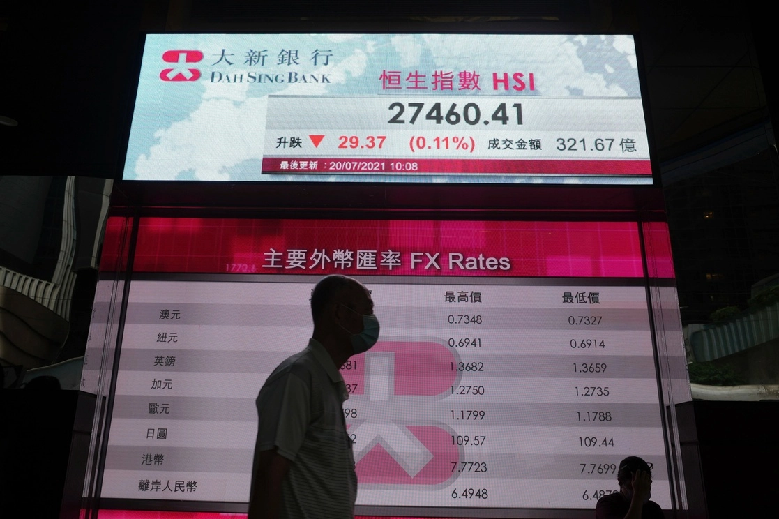 Un hombre camina frente a una pizarra electrónica del índice bursátil de Hong Kong. Los valores asiáticos caían el martes, tras una ola de nerviosismo por la expansión de la versión delta del Covid-19. Foto Ap