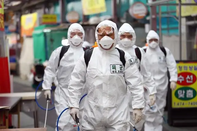 Soldados surcoreanos con trajes de protección desinfectan un mercado en Daegu, como medida contra la propagación del coronavirus. Foto Afp 