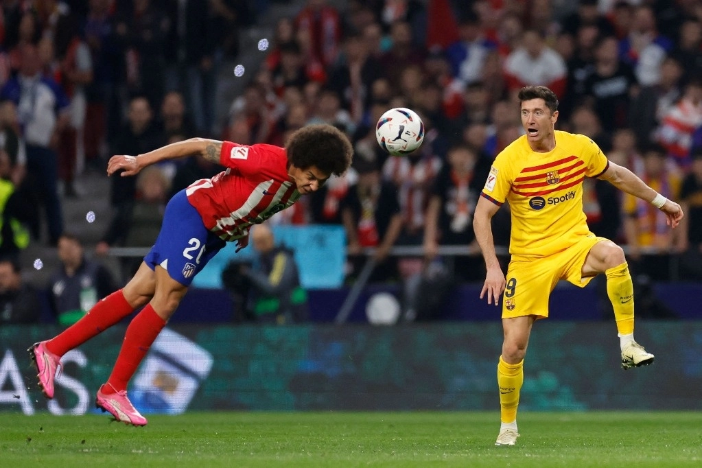 El centrocampista belga #20 del Atlético de Madrid Axel Witsel (L) compite por el balón con el delantero polaco del Barcelona #09 Robert Lewandowski durante el partido de fútbol de la liga española entre el Club Atlético de Madrid y el FC Barcelona en el estadio Metropolitano de Madrid el 17 de marzo de 2024. Foto Afp 