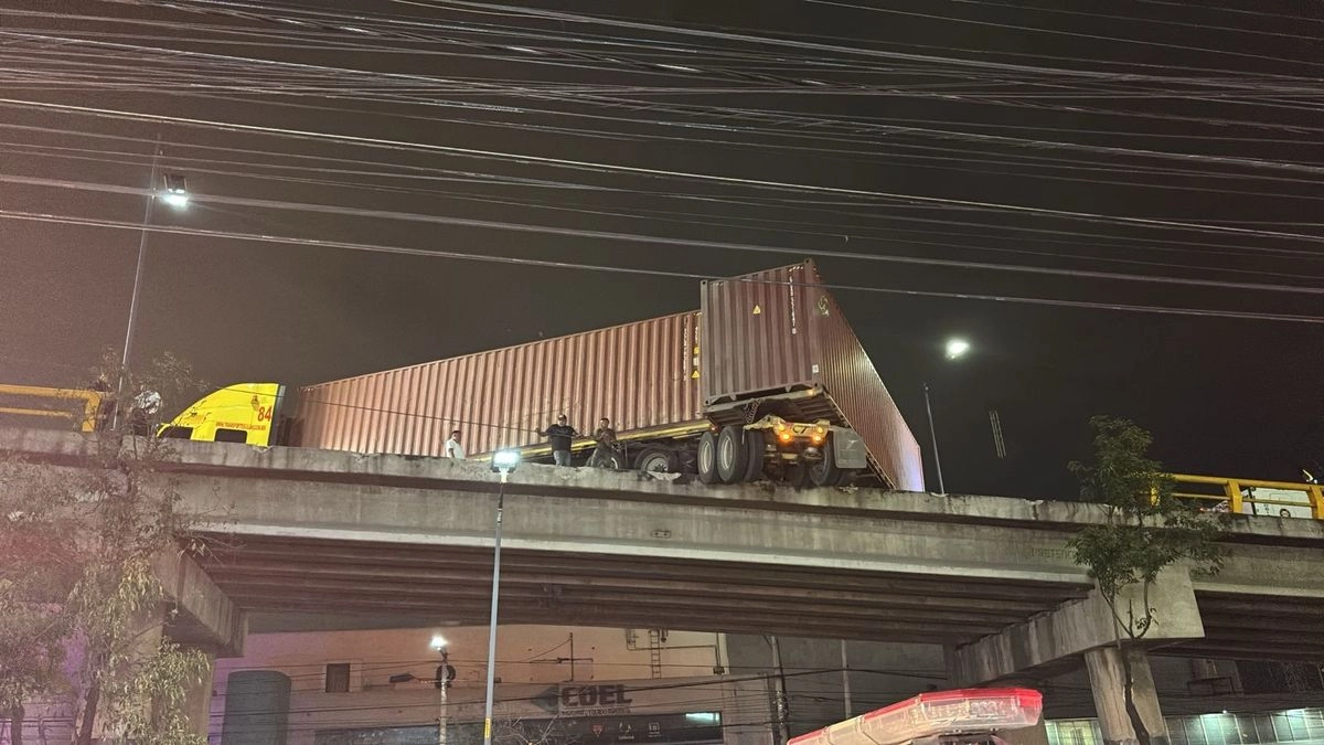 Elementos de protección civil y bomberos realizaron trabajos para retirar al tractocamión de doble remolque del puente vehicular ubicado en Naucalpan, Estado de México. Foto 