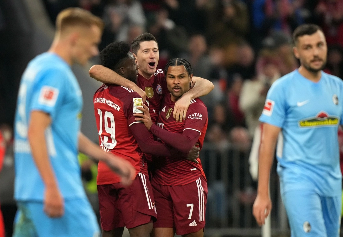 Robert Lewandowski celebra con sus compañeros del Bayern, Alphonso Davies y Serge Gnabry, su gol número 13 de la temporada. Foto Ap  