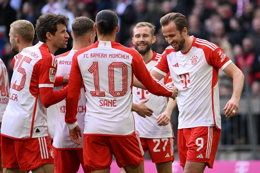 Harry Kane (derecha) celebra con sus compañeros uno de los tres goles que anotó en la goleada de 8-1 que el Bayern Múnich le propinó a Maguncia en la fecha 25 de la Bundesliga. Foto Afp
