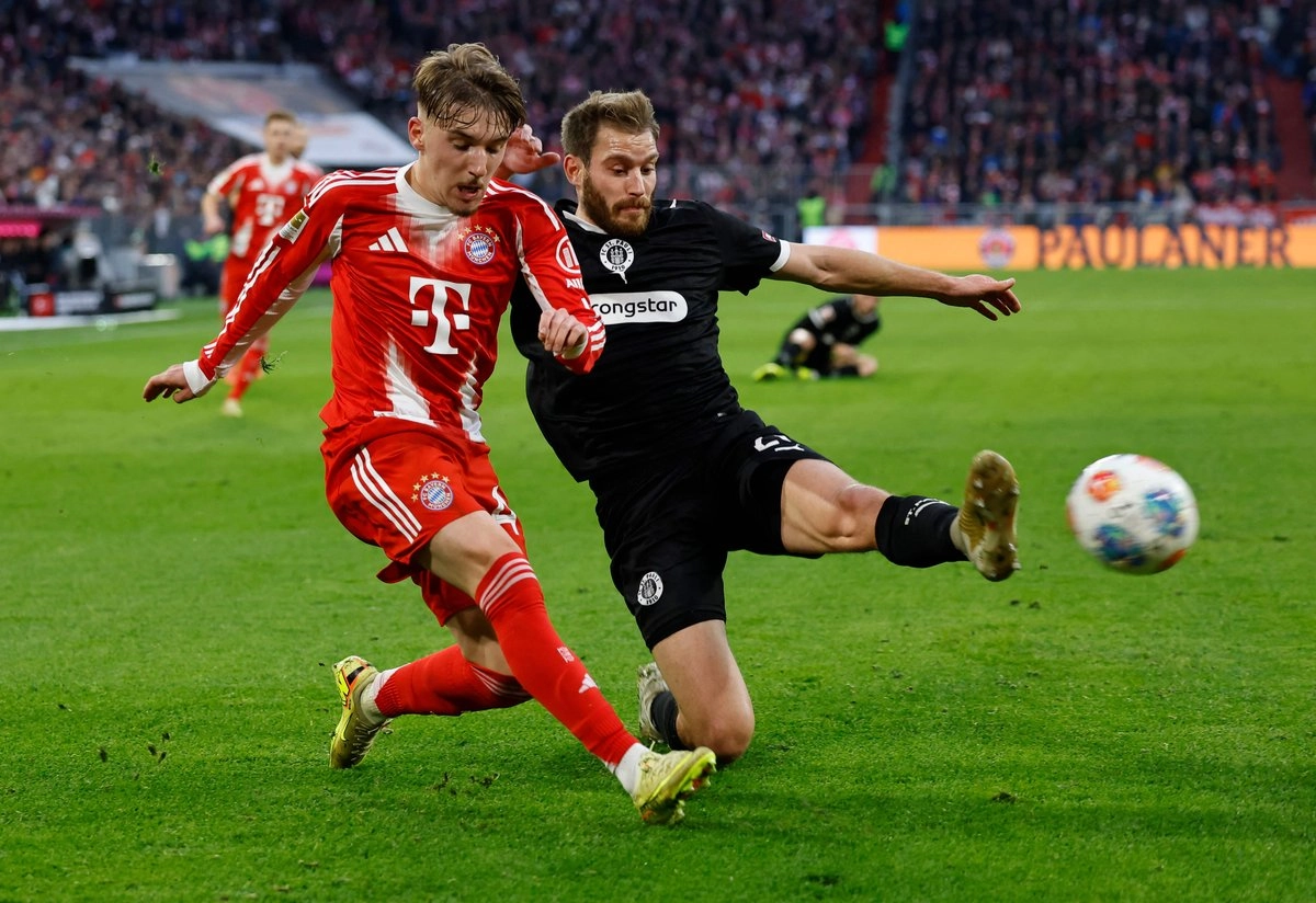 El centrocampista del Bayern, Munich Lennart Karl, (izquiera) y el defensa del St Pauli, Lars Ritzka, disputan el balón en la cancha del estadio Allianz Arena, el 29 de noviembre de 2025. Foto