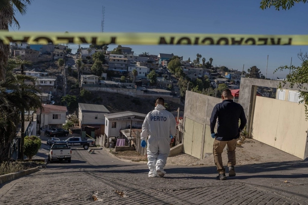 Autoridades delimitan zona donde apareció el cuerpo de una persona asesinada, con un narcomensaje, en Tijuana, BC. Foto Cuartoscuro / Archivo
