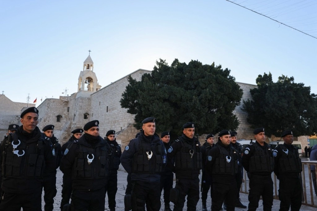 Policías palestinos hacen guardia en la Plaza del Pesebre antes del desfile de Nochebuena frente a la Iglesia de la Natividad de Belén, en Cisjordania ocupada por Israel, el 24 de diciembre de 2024. Foto Afp
