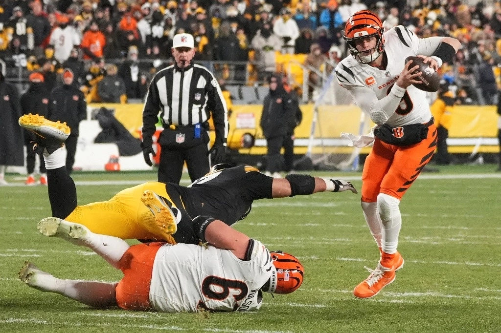 El quarterback de los Cincinnati Bengals, Joe Burrow (9), evita al tackle defensivo de los Pittsburgh Steelers, Cameron Heyward (97), con el guardia de los Cincinnati Bengals, Cordell Volson (67), durante la segunda mitad de un partido de fútbol americano de la NFL en Pittsburgh, el sábado 4 de enero de 2025. Foto Ap