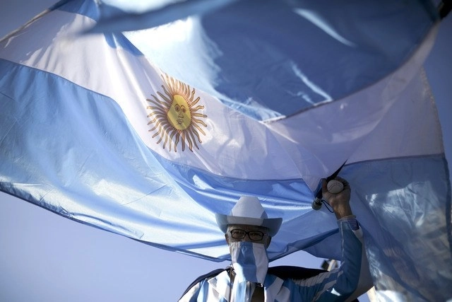 Persona sujeta la bandera de Argentina en imagen de archivo. Foto Ap