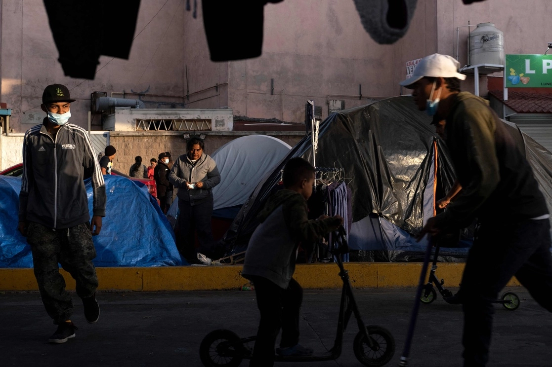 Niños juegan en un campamento de migrantes en Tijuana, Baja California, mientras esperan la respuesta de autoridades estadunidenses a su solicitud de asilo, el pasado 14 de abril de 2021. Foto Afp