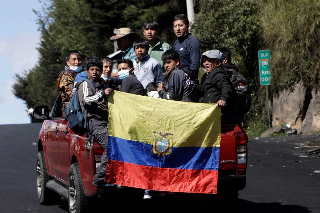Indígenas con la bandera de Ecuador pasan por un vecindario del sur de Quito, el 16 de junio de 2022. Foto Afp 