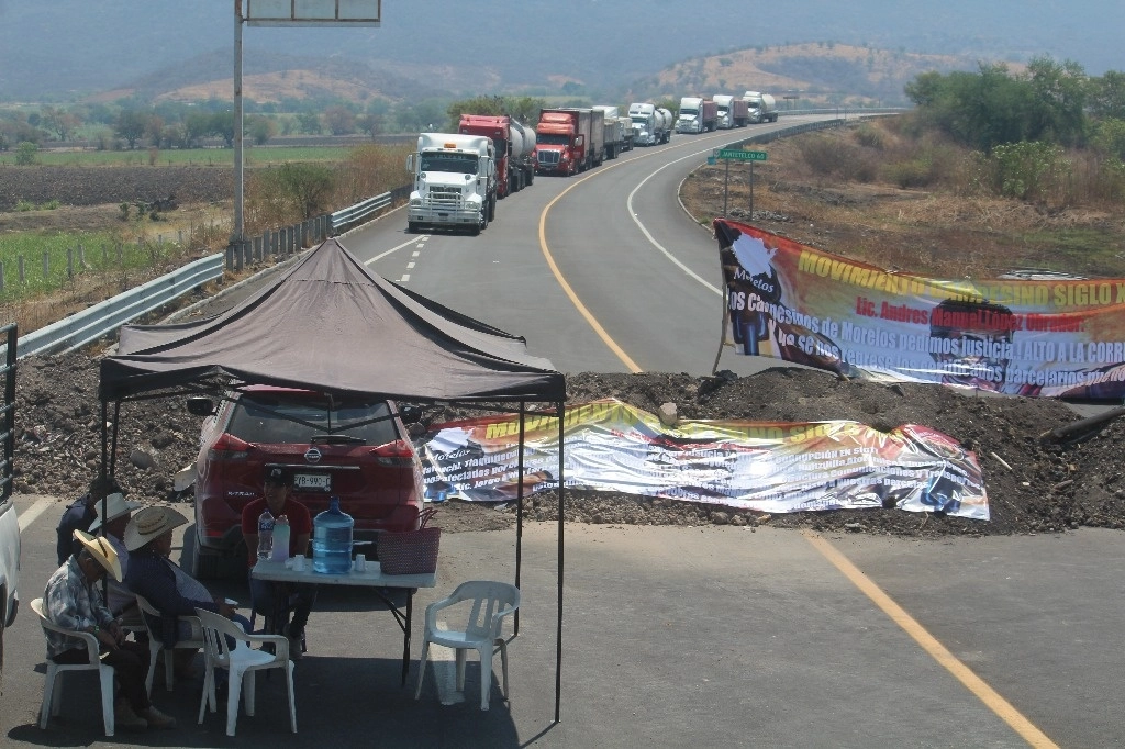 Decenas de transportistas quedaron varados en la autopista Siglo XXI luego de que ejidatarios de distintos municipios de Morelos bloquearon ayer con montículos de tierra la carretera México-Acapulco, que comunica con Puebla. Foto Rubicela Morelos Cruz