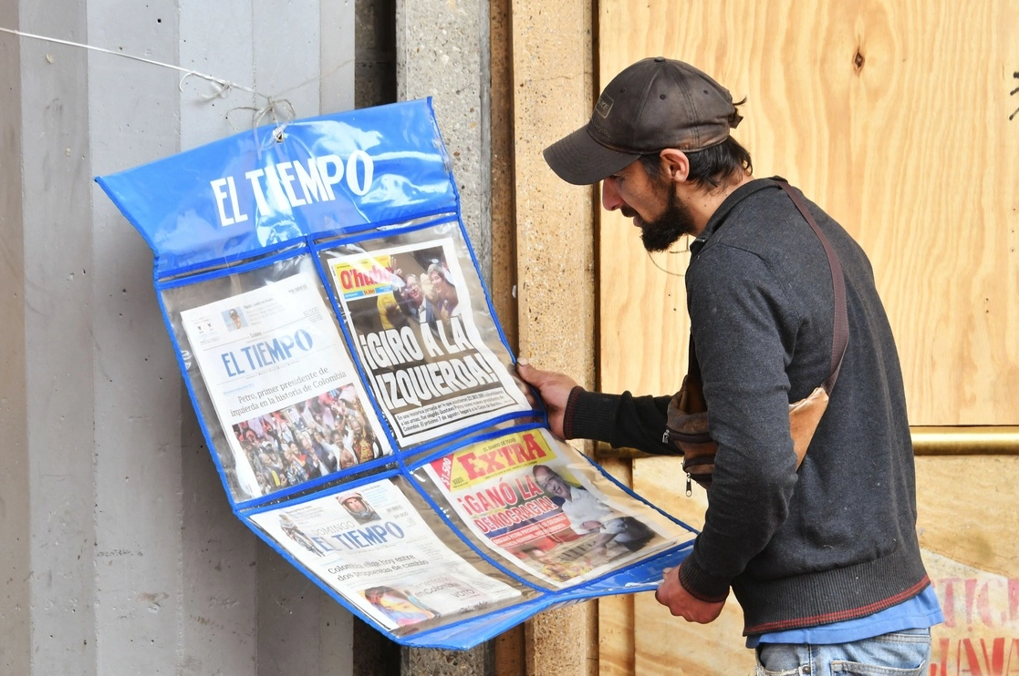 La Bolsa de Colombia se desplomaba este martes cinco por ciento a mil 381.74 puntos en la apertura de la jornada, luego de que el izquierdista Gustavo Petro ganó las elecciones presidenciales. En la imagen, un hombre mira las portadas de los periódicos locales el día después de la jornada electora, el 20 de junio de 2022. Foto Afp