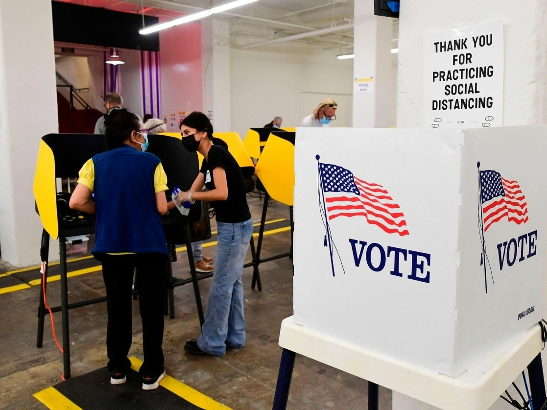 Un votante recibe asistencia de un trabajador electoral en un centro de votación en Grand Central Market en Los Ángeles, California. Foto AFP
