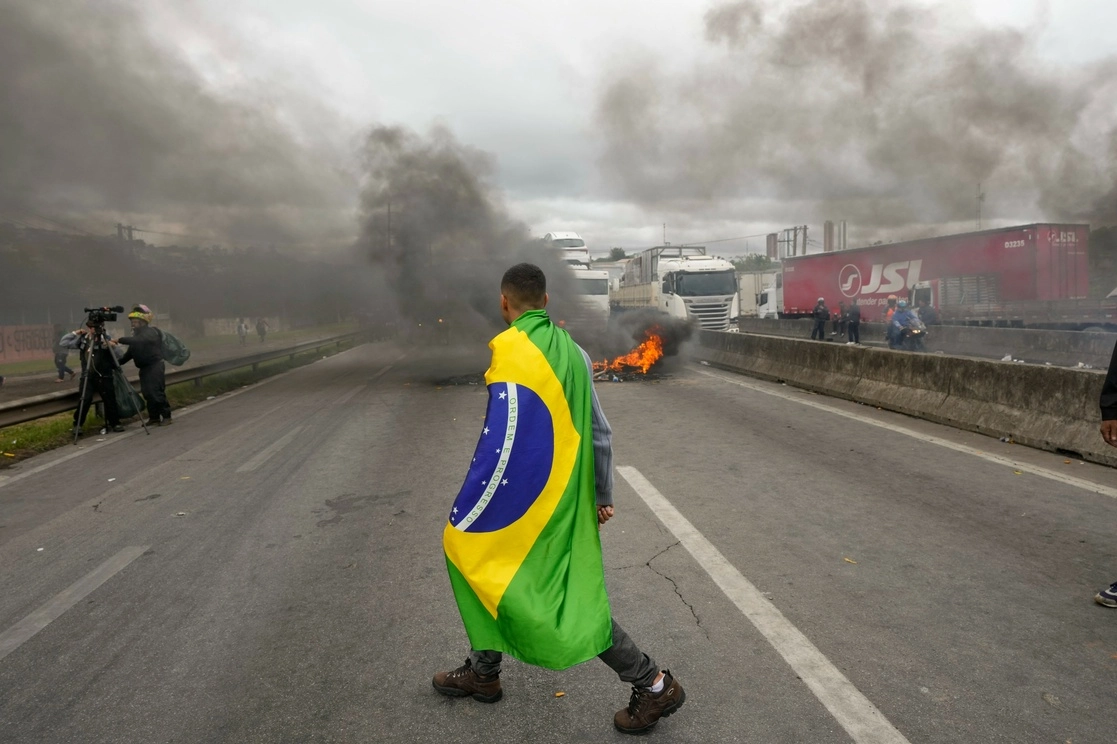Un manifestante con la bandera brasileña, durante los bloqueos carreteros de simpatizantes del presidente Jair Bolsonaro, hoy a las afueras de Sao Paulo. Foto Ap 