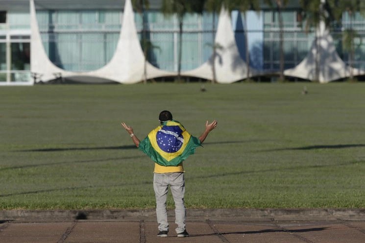 Un simpatizante del presidente brasileño Jair Bolsonaro ora frente al Palacio de la Alvorada en medio del brote de la enfermedad causada por el nuevo coronavirus. Foto Xinhua
