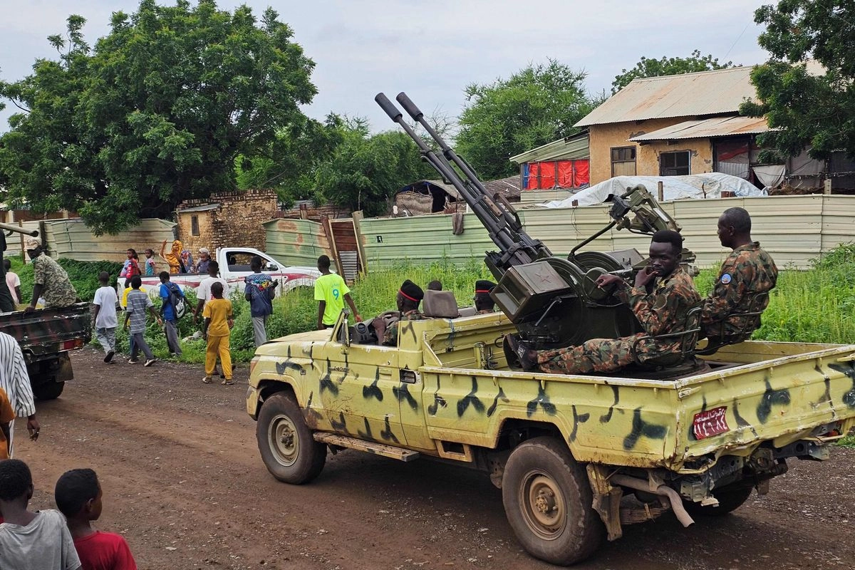 Desde su inicio en abril de 2023, la guerra sudanesa entre el ejército regular y su rival paramilitar, las Fuerzas de Apoyo Rápido (FAR), ha causado la muerte de decenas de miles de personas y ha obligado a millones a abandonar sus hogares. En la imagen, niños caminan junto al ejército sudanés en la calle Gedaref, en el este de Sudán, el 14 de agosto de 2025. 