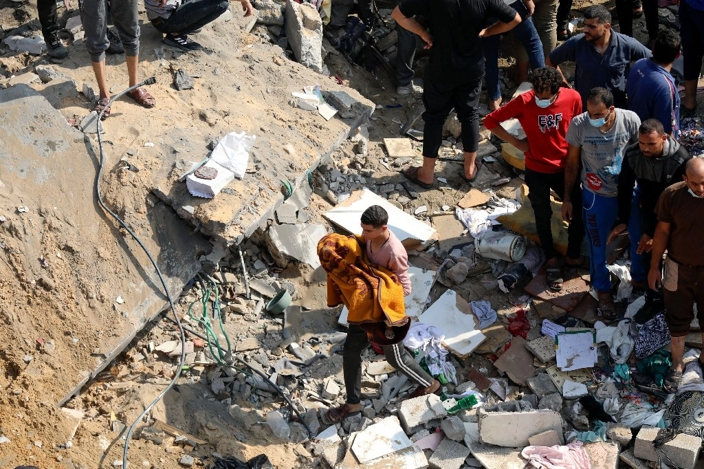 Un hombre palestino carga a una niña muerta que fue encontrada bajo los escombros de un edificio destruido, tras los ataques aéreos israelíes en el campo de refugiados de Jabaliya, al norte de la Franja de Gaza, el 1 de noviembre de 2023. Foto Ap