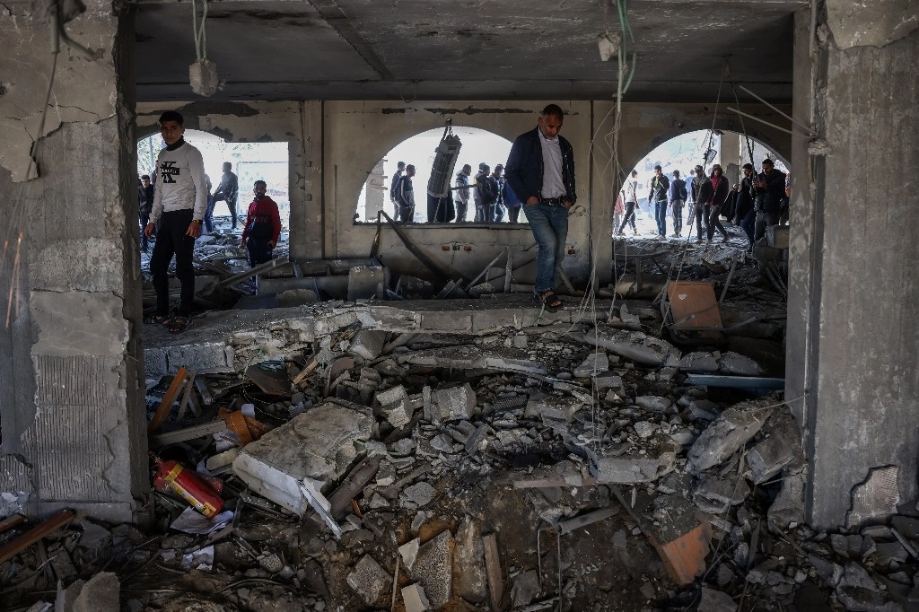 Palestinos reunidos en un edificio destruido por ataques israelíes en Jan Yunis, al sur de la franja de Gaza. Foto Xinhua