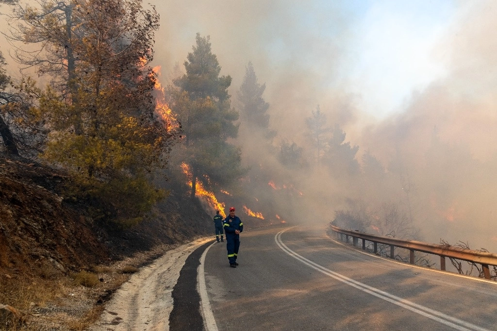 Bomberos trabajan en el sitio del incendio forestal, en el suburbio Varnavas, a unos 35 km de Atenas, Grecia. Foto Xinhua