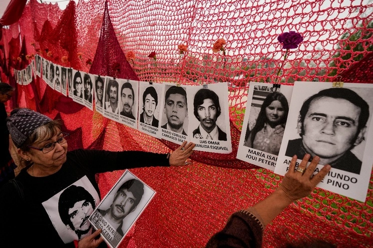 Familiares y amigos de detenidos y desaparecidos durante el régimen del general Augusto Pinochet asisten a una ceremonia pública en la que se anunció que el gobierno recuperó la administración de una propiedad que funcionó como centro de tortura hace 50 años. Foto Ap