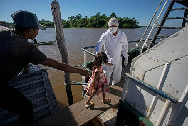 Trabajador médico en Brasil atiende a menor en la comunidad de Salvacao, en el estado de Pará. Foto Afp