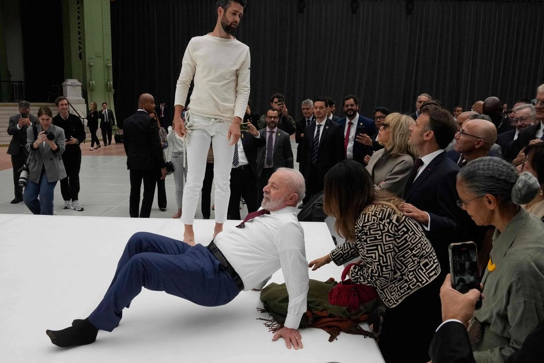 El presidente de Brasil, Luiz Inácio Lula da Silva, intenta imitar un movimiento de acróbatas durante una visita a una exposición en el marco de su visita de Estado a Francia, el 6 de junio de 2025, en el Grand Palais de París. Foto