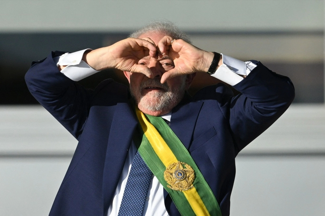 Luiz Inácio Lula da Silva, nuevo presidente de Brasil, hace una señal de corazón con las manos en el Palacio de Planalto, donde miles de sus seguidores se dieron cita para acompañarlo en su toma de posesión para el cargo por tercera ocasión, el 1 de enero de 2023. Foto Afp /Archivo