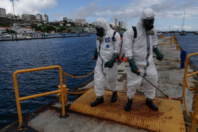 En Bahía, Barsil, marinos realizan tareas de desinfección en el para evitar la propagación del Covid-19. Foto Xinhua