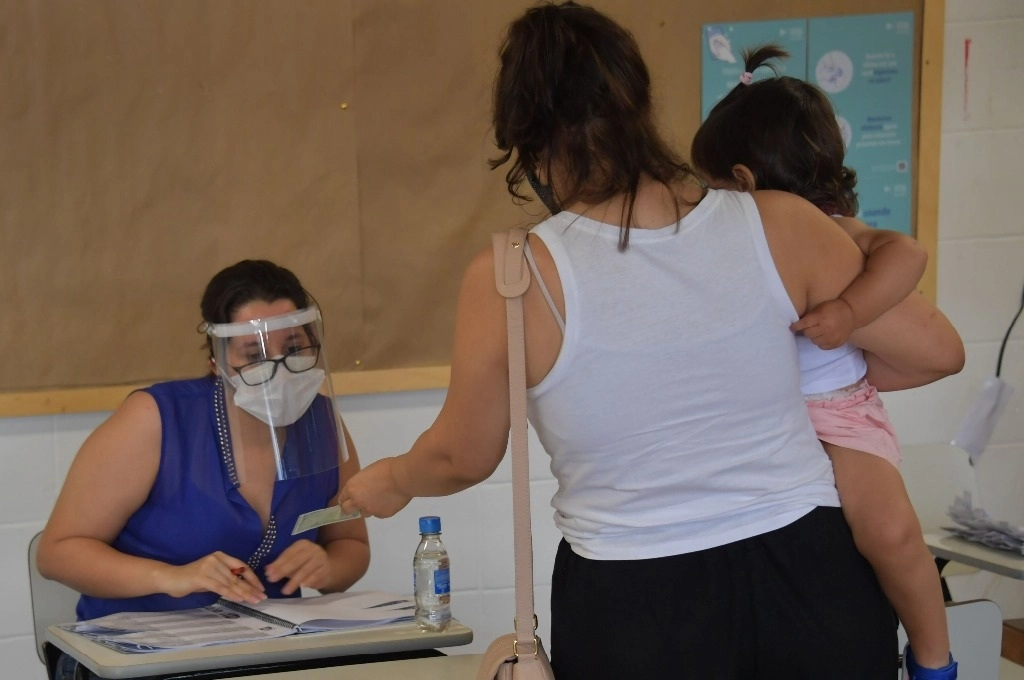 Una señora muestra su identificación antes de votar el domingo en las elecciones municipales de Sao Paulo. Foto Afp